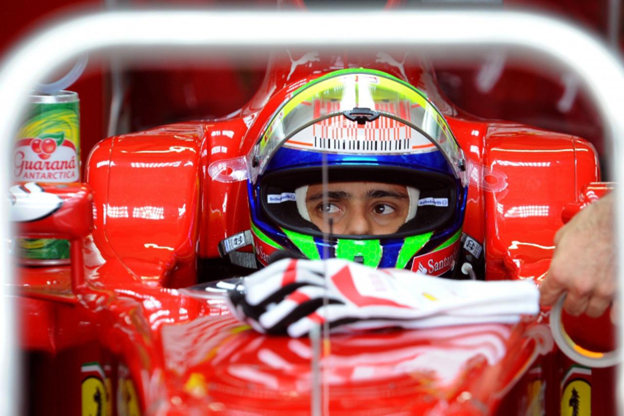 'Ferrari\'s Brazilian driver Felipe Massa sits in his car in the pits of the Hockenheimring circuit on July 24, 2010 in Hockenheim, during the third free practice session of the Formula One German Gra
