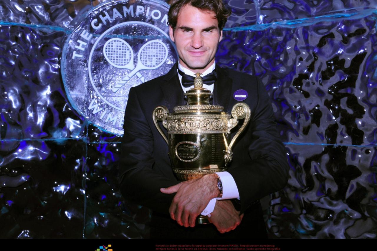 'Switzerland\'s Roger Federer holds the Men\'s Singles Trophy during the Champions Ball at the Intercontinental Hotel, London. Photo: Press Association/Pixsell'