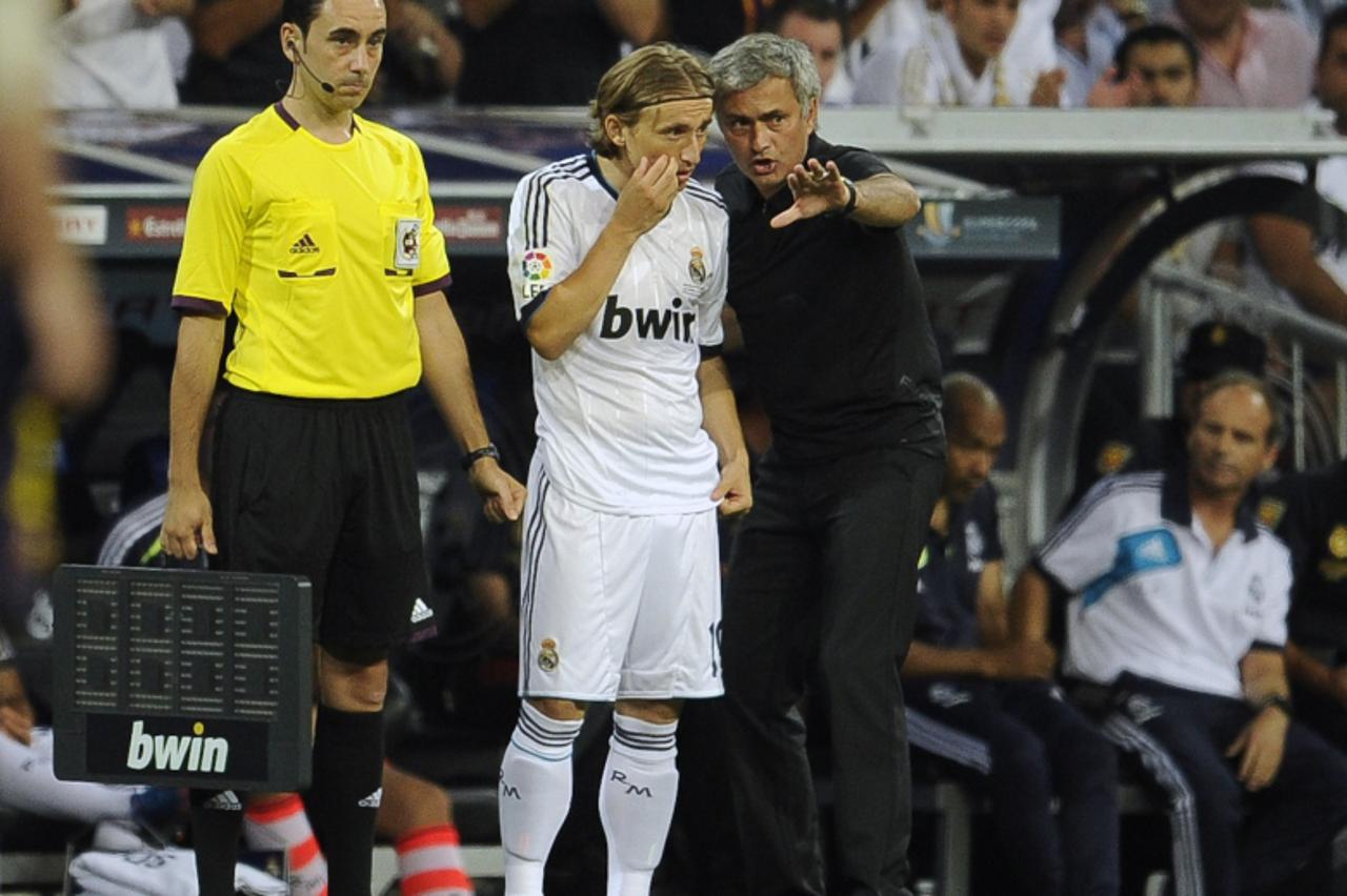 'Real Madrid\'s Croatian midfielder Luka Modric (C) listens to his coach Jose Mourinho (R) during the second leg of the Spanish Supercup football match Real Madrid CF vs FC Barcelona on August 29, 201