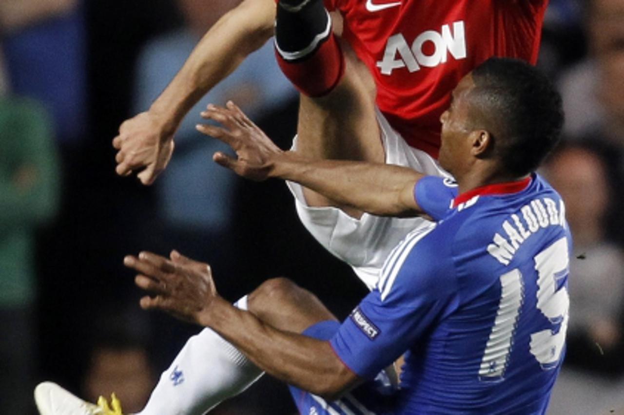 \'Manchester United\'s Rio Ferdinand (L) challenges Chelsea\'s Florent Malouda during the first leg of their Champions League quarter final soccer match at Stamford Bridge in London April 6, 2011.    