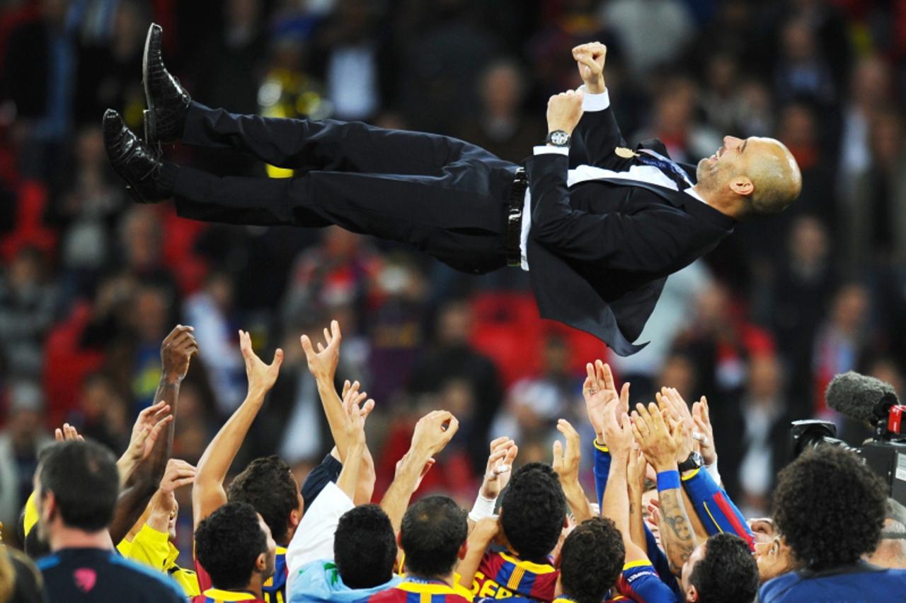 \'AFP PICTURES OF THE YEAR 2011   Barcelona\'s Spanish coach Josep Guardiola is put through in the air in celebration  at the end of the UEFA Champions League final football match FC Barcelona vs. Man