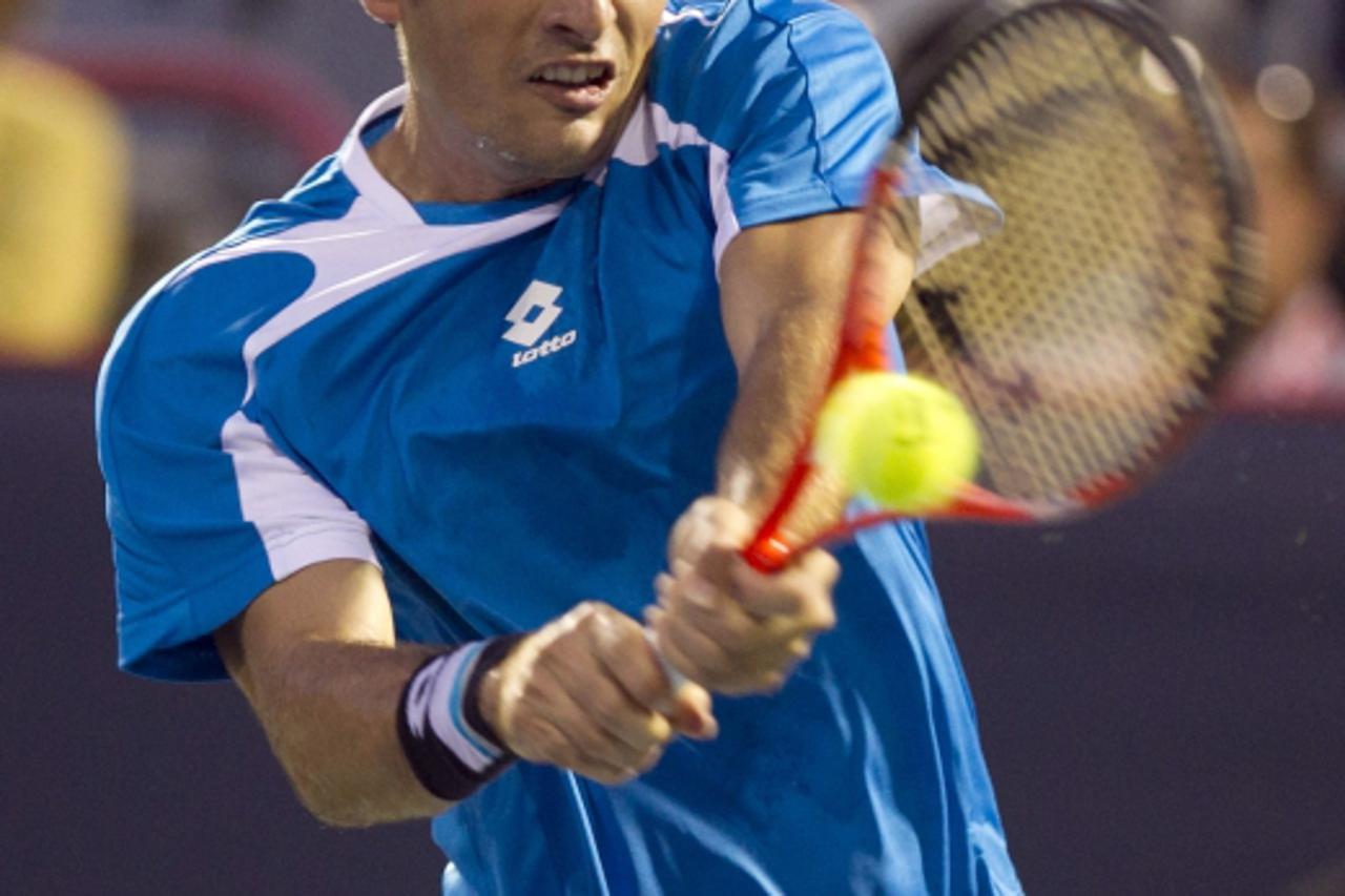 'Croatia\'s Ivan Dodig hits a return to Spain\'s Rafael Nadal at the Rogers Cup tennis tournament in Montreal, August 10, 2011.  REUTERS/Christinne Muschi(CANADA - Tags: SPORT TENNIS)'