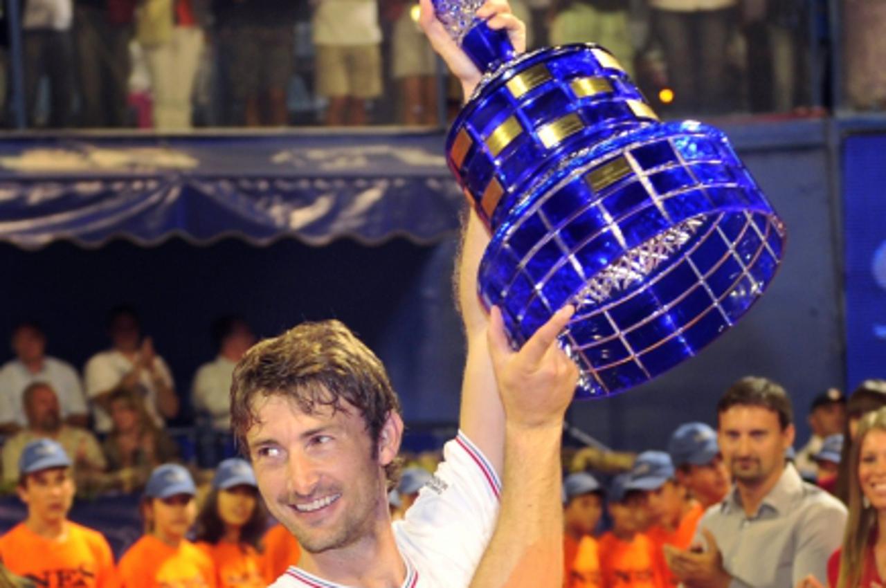 'Spain\'s Juan Carlos Ferrero celebrates with the trophy after his 6-4, 6-4 victory on Italy\'s Potito Starace (not pictured) during their final match of the ATP Croatia Open tennis tournament in the 