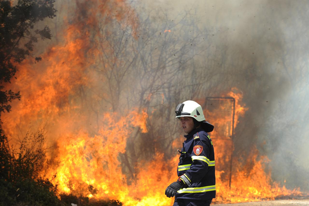 Vodice, 100912. Veliki sumski pozar u podrucju Kovca u zaledju Vodica kod mjesta Gaceleze, gase 5 kanadera i preko 50 vatrogasaca. Zbog miniranog terena vatrogasci ne mogu sici sa ceste.  Foto: Niksa Stipanicev / CROPIX