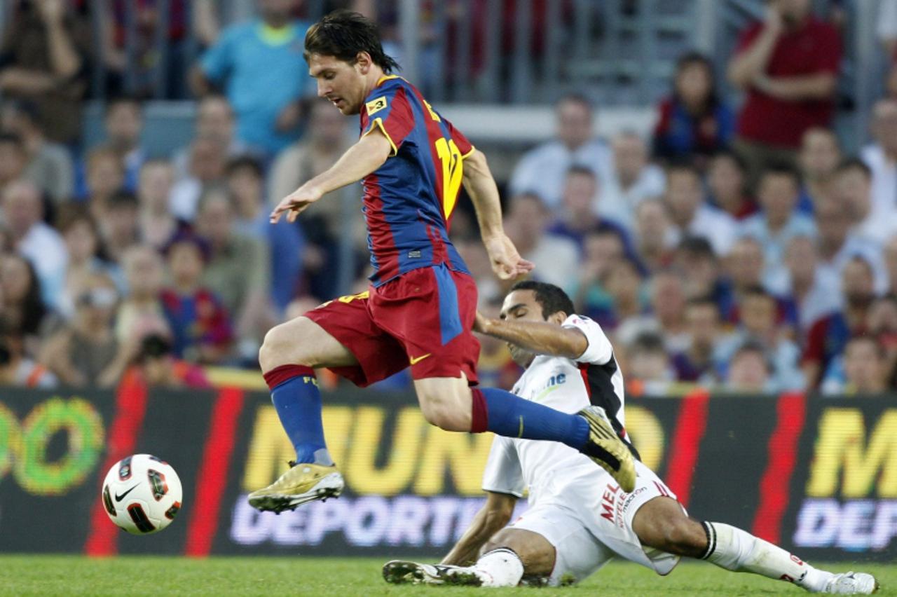 \'Barcelona\'s Lionel Messi goes past Real Mallorca\'s Joao Victor during their Spanish first division soccer match at Nou Camp stadium in Barcelona October 3, 2010.   REUTERS/Gustau Nacarino (SPAIN -
