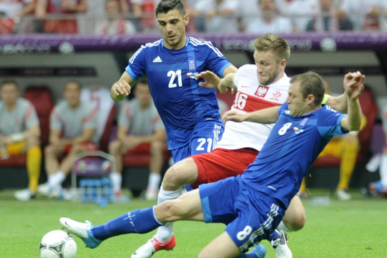 'Greece\'s Kostas Katsouranis and Avraam Papadopoulos (R) challenge Poland\'s Jakub Blaszczykowski (C) during their Group A Euro 2012 soccer match at the National stadium in Warsaw June 8, 2012.      