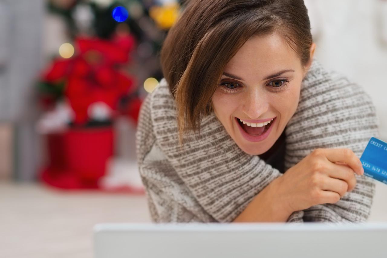 Surprised woman with laptop and credit card near Christmas tree; Shutterstock ID 121088614; PO: aol; Job: production; Client: drone