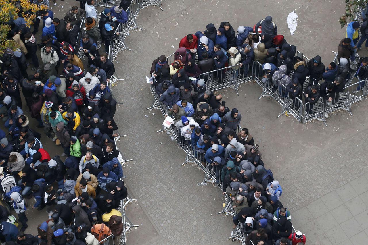 Migrants queue in the compound outside the Berlin Office of Health and Social Affairs (LAGESO) as they wait to register in Berlin, Germany, October 7, 2015. German authorities are struggling to cope with the roughly 10,000 refugees arriving every day, man