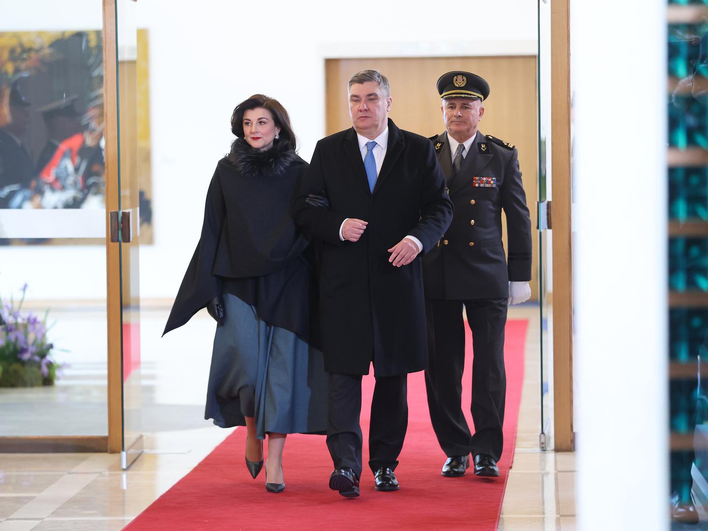 Sanja Milanović, supruga Zorana Milanovića,  nije razočarala ni ovaj put. Odabrala je haljinu sivkaste petrolej boje preko koje je nosila crnu pelerinu.
