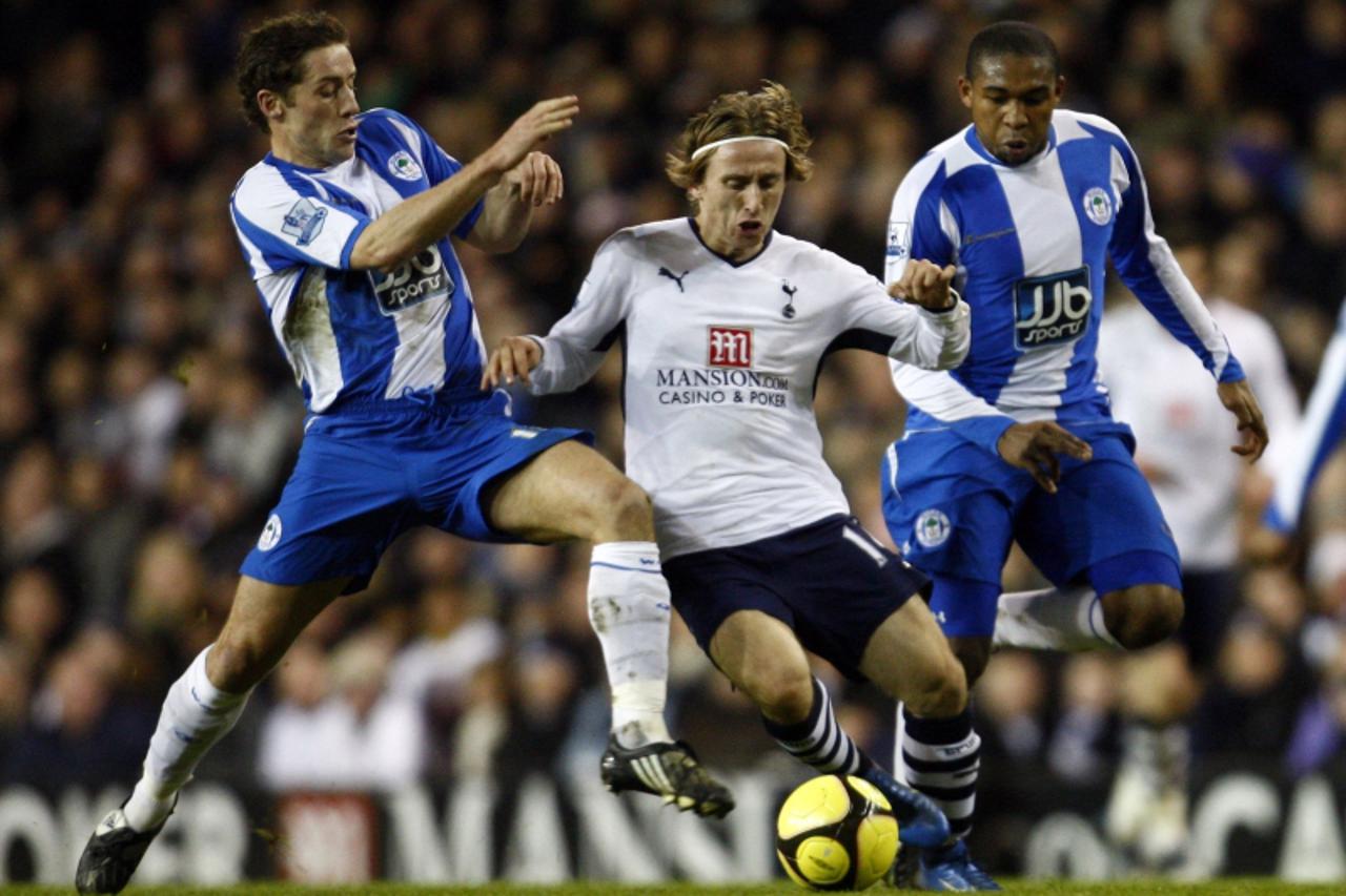 \'Luka Modric (C) of Tottenham Hotspur is challenged by Wigan Athletic\'s Wilson Palacios (R) and Michael Brown (L) during their English FA Cup third round soccer match at White Hart Lane in London Ja