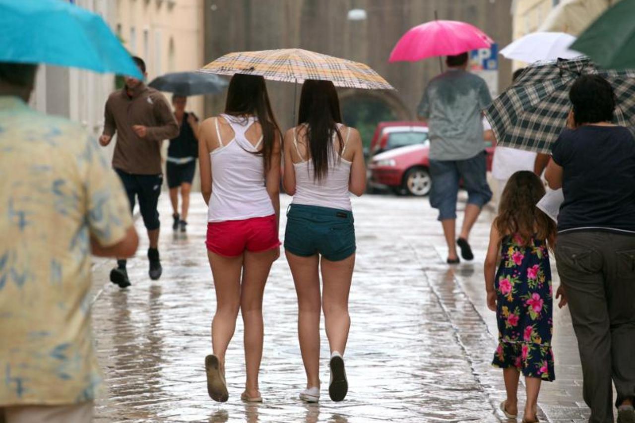 '24.06.2013., Zadar - Kisa opustjela ulice na trenutak. Turisti koji su ze zatekli u gradu brzo su pronasli spas u gradskim prolazima i nadstresnicama, a mnogima nije smetala ni setnja po kisi.  Photo