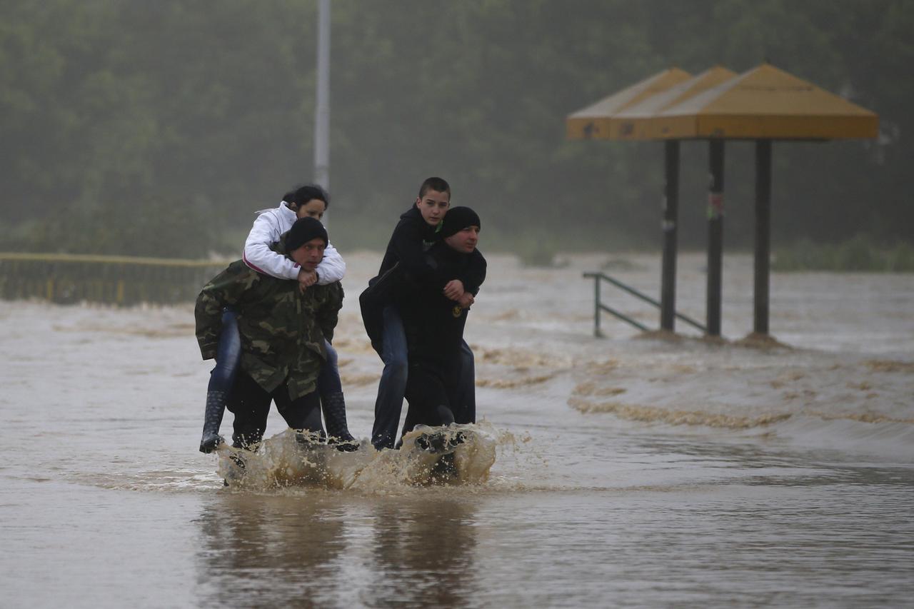 REFILE - CORRECTING DIRECTION OF TOWN FROM BELGRADE   Two men carry a woman and a boy through a flooded street in the town of Obrenovac, southwest of Belgrade May 16, 2014. The heaviest rains and floods in 120 years have hit Bosnia and Serbia, killing fiv