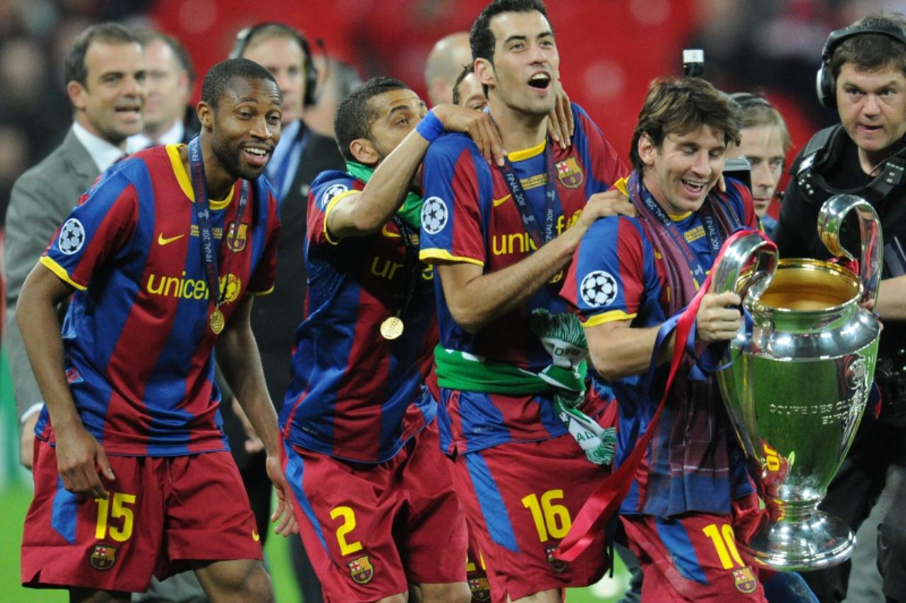 \'Barcelona\'s Argentinian forward Lionel Messi (R) and teammates celebrate with the trophy at the end of the UEFA Champions League final football match FC Barcelona vs. Manchester United, on May 28, 