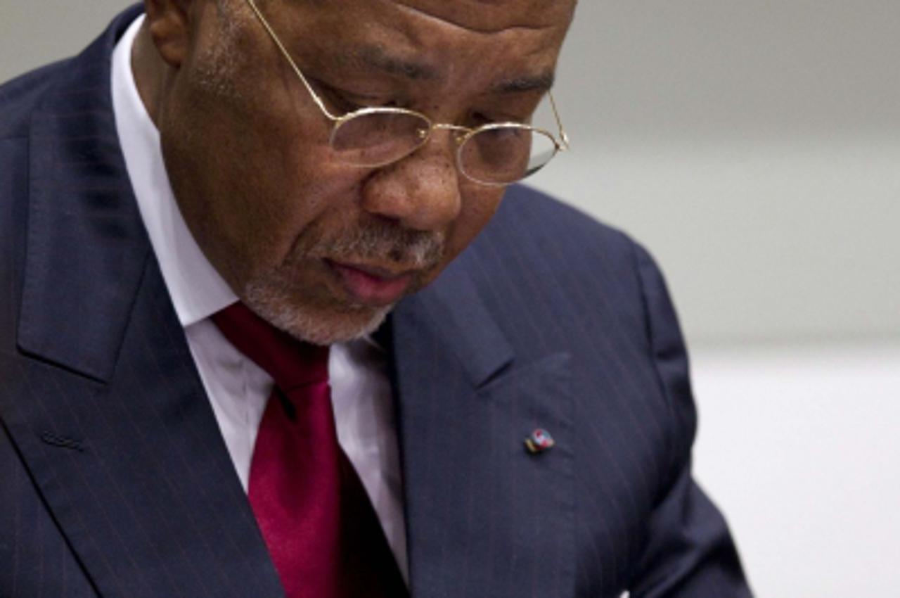 'Former Liberian President Charles Taylor takes notes as he waits for the start of a hearing to receive a verdict in a court room of the Special Court for Sierra Leone in Leidschendam, near The Hague,