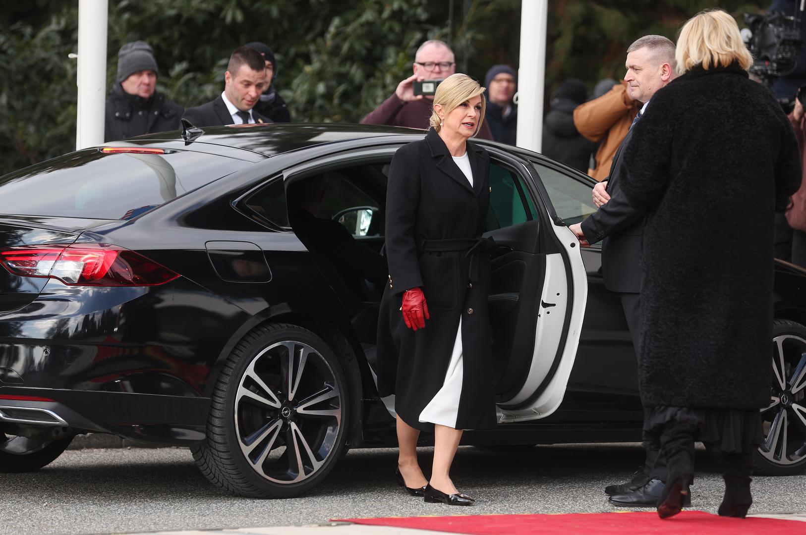 Bivša predsjednica Kolinda Grabar Kitarović odabrala je bijelu elegantnu haljinu, crni kaput i jednostavne balerinke. Kombinaciju je podignula upečatljivim crvenim rukavicama. Nakon ulaska na Pantovčak, balerinke je zamijenila bijelim salonkama