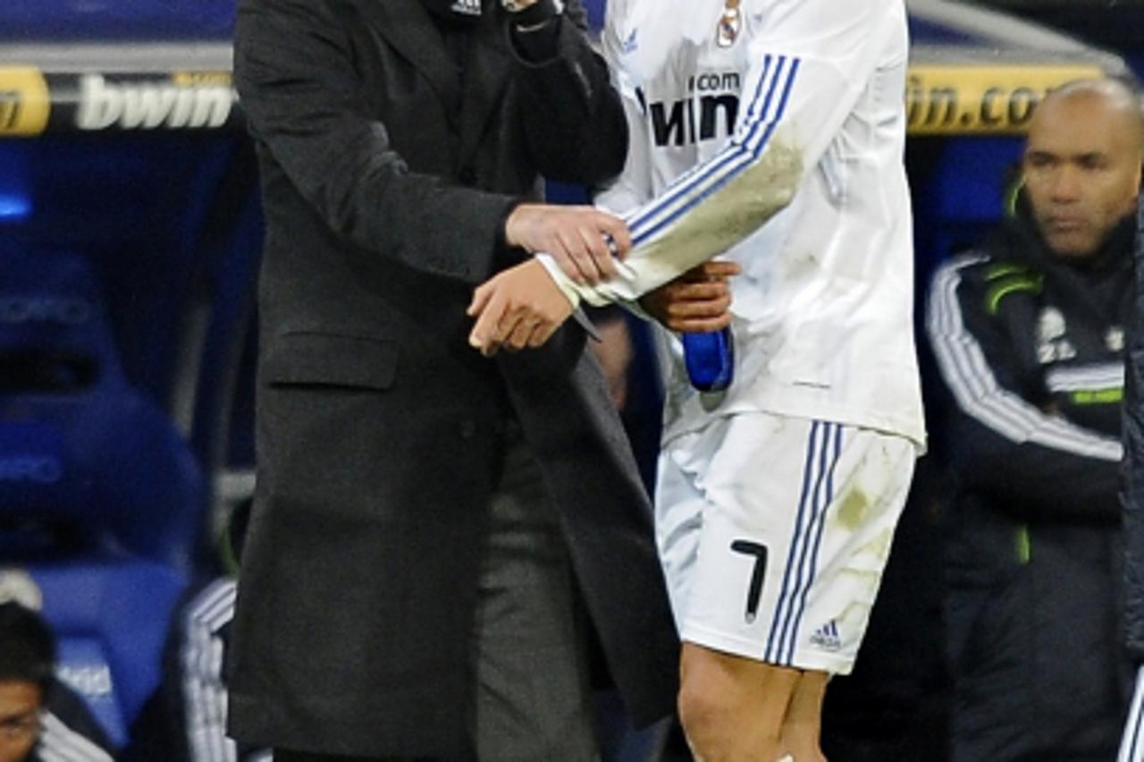 'Real Madrid\'s Portuguese coach Jose Mourinho (L) gives instructions to Real Madrid\'s Portuguese forward Cristiano Ronaldo (R) during the Spanish league football match Real Madrid CF vs Villarreal C