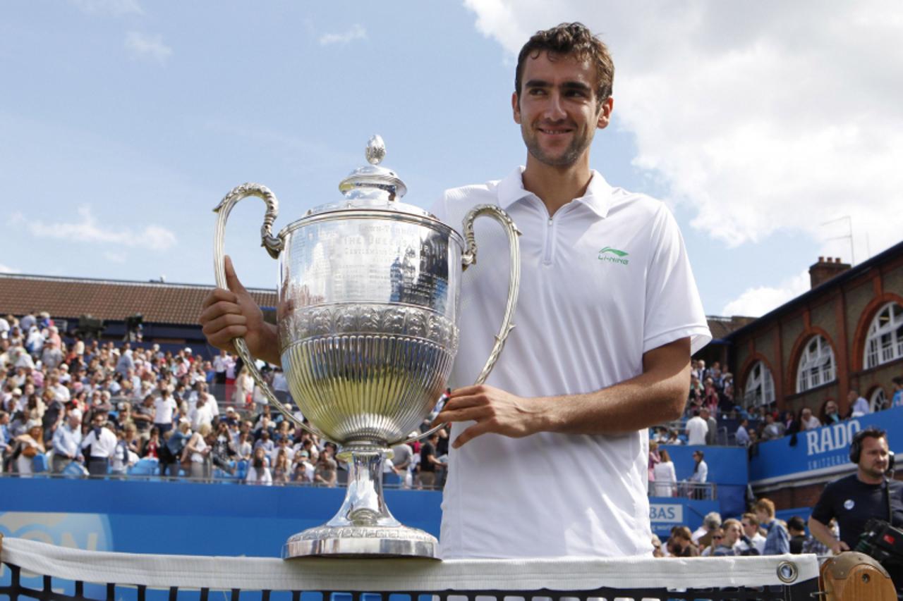 'Marin Cilic of Croatia holds his trophy after winning his men\'s singles final match against  David Nalbandian of Argentina, who lost by default at the Queen\'s Club tennis tournament in London June 