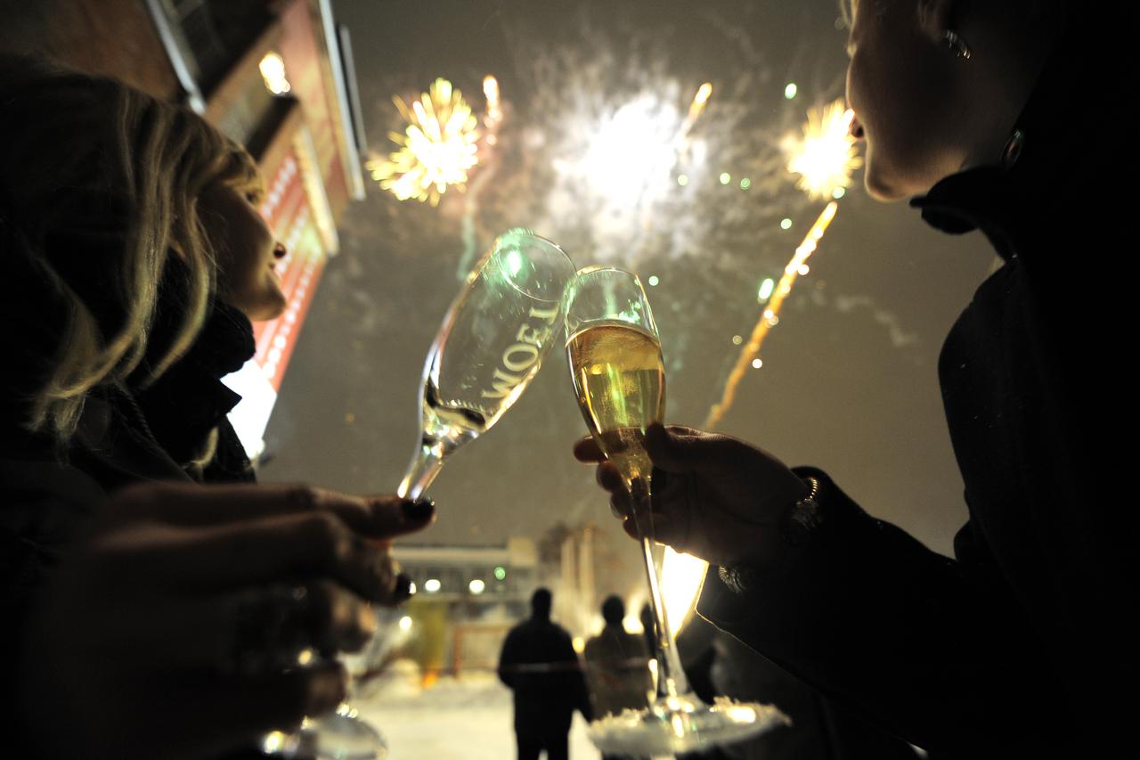 Two women toast as fireworks explode during an outside party in Berlin's Kreuzberg district to celebrate the New Year on January 1, 2010. AFP PHOTO DDP / TIMUR EMEK   GERMANY OUT (Photo credit should read TIMUR EMEK/AFP/Getty Images)