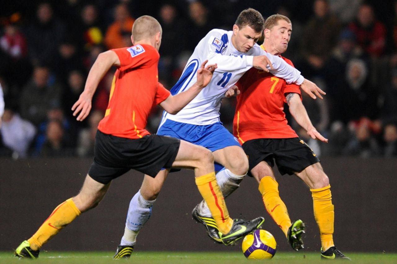 'Bosnia Herzevogina\'s Edin Dzeko (C) vies with Belgian\'s immy Simons (R) during their World Cup 2010 qualifying match in Genk on March 28, 2009. AFP PHOTO JOHN THYS'