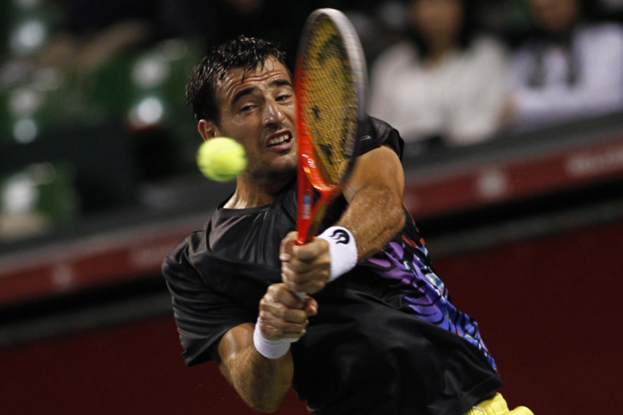 'Ivan Dodig of Croatia returns a shot against Jo-Wilfried Tsonga of France during their men\'s singles match at the Japan Open tennis championships in Tokyo October 2, 2013. REUTERS/Yuya Shino (JAPAN 
