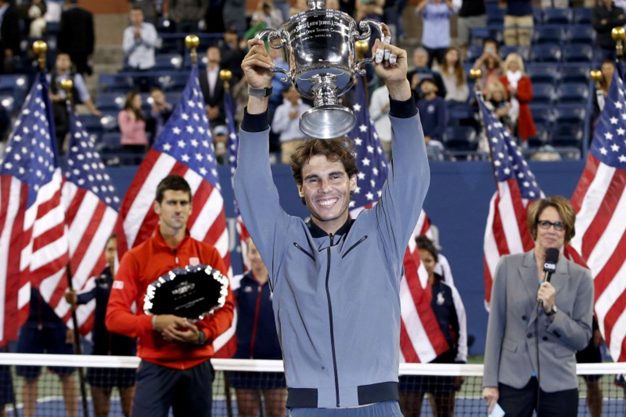 'Rafael Nadal of Spain raises his trophy after defeating Novak Djokovic of Serbia (L) in their men\'s final match at the U.S. Open tennis championships in New York, September 9, 2013.                 