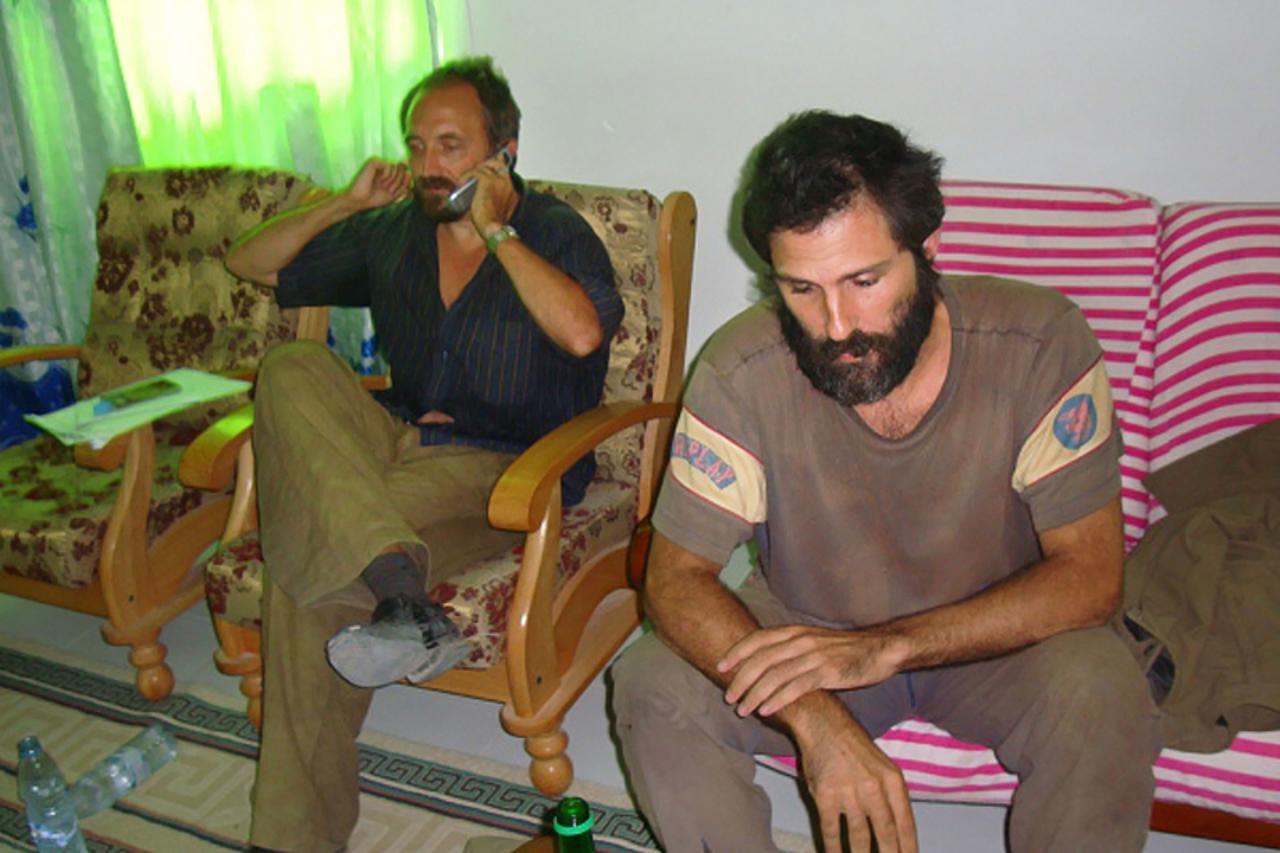 \'British reporter Colin Freeman [L] makes a phone call January 4, 2008 following  release along with Spanish photographer, Jose Cendon [R] at Somalia\'s breakaway Puntland state\'s port town of Bosas