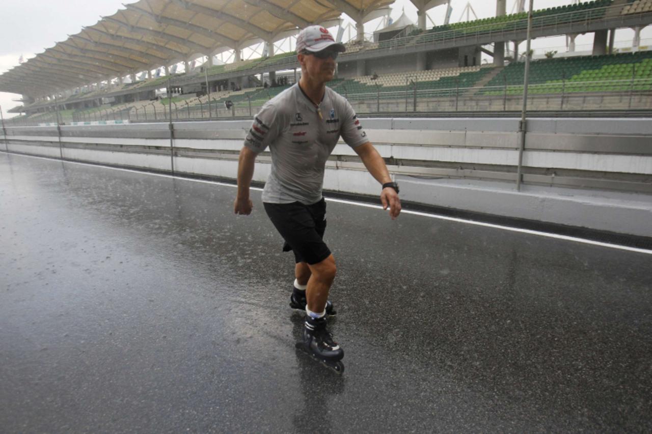 'Mercedes Formula One driver Michael Schumacher of Germany roller blades down the track in the rain ahead of the Malaysian F1 Grand Prix at the Sepang circuit outside Kuala Lumpur April 7, 2011. REUTE