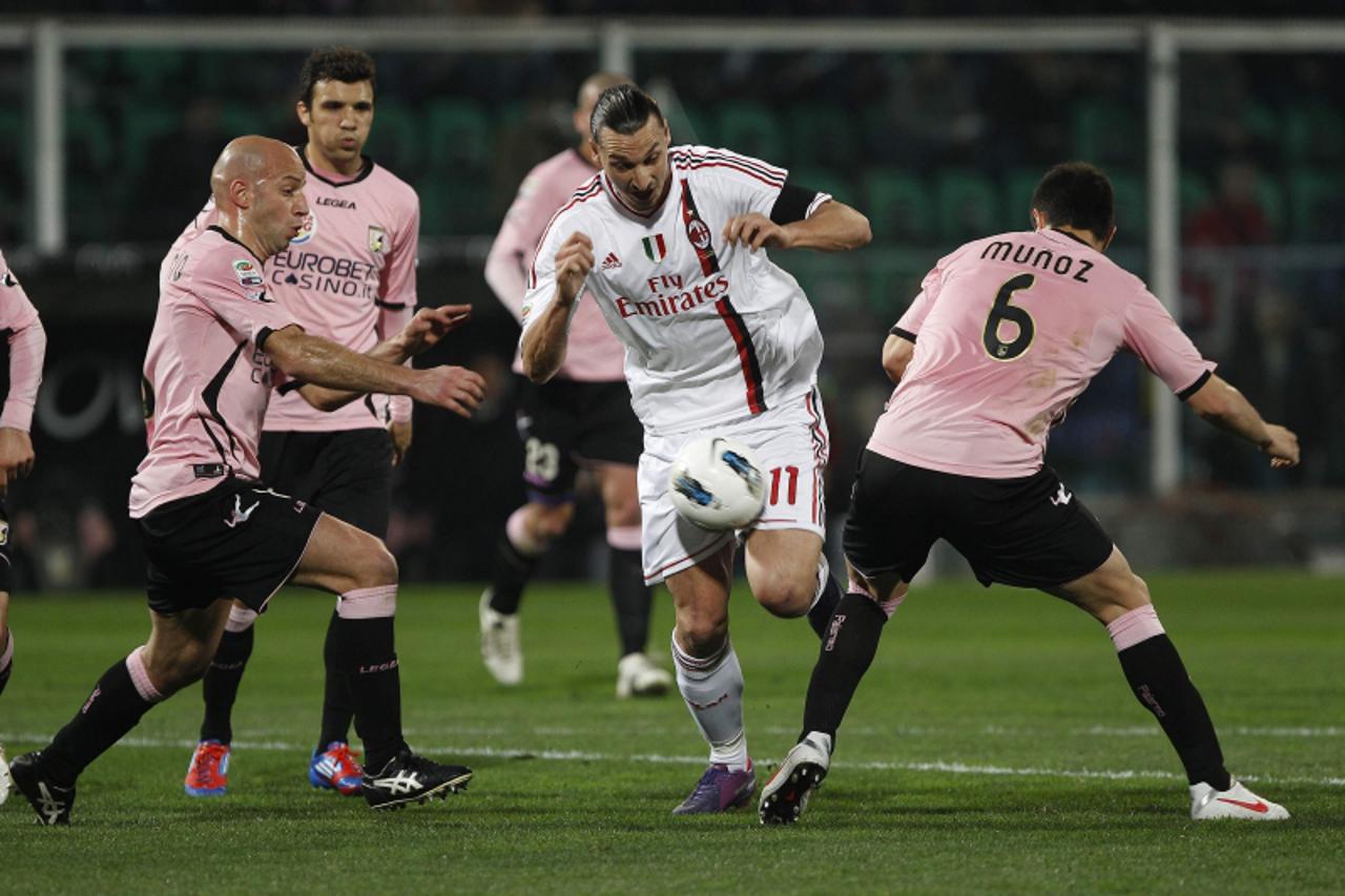 'AC Milan\'s Zlatan Ibrahimovic (C) is challenged by Palermo\'s Ezequiel Munoz and Giulio Migliaccio (L) during their Italian Serie A soccer match at the Renzo Barbera stadium in Palermo March 3, 2012