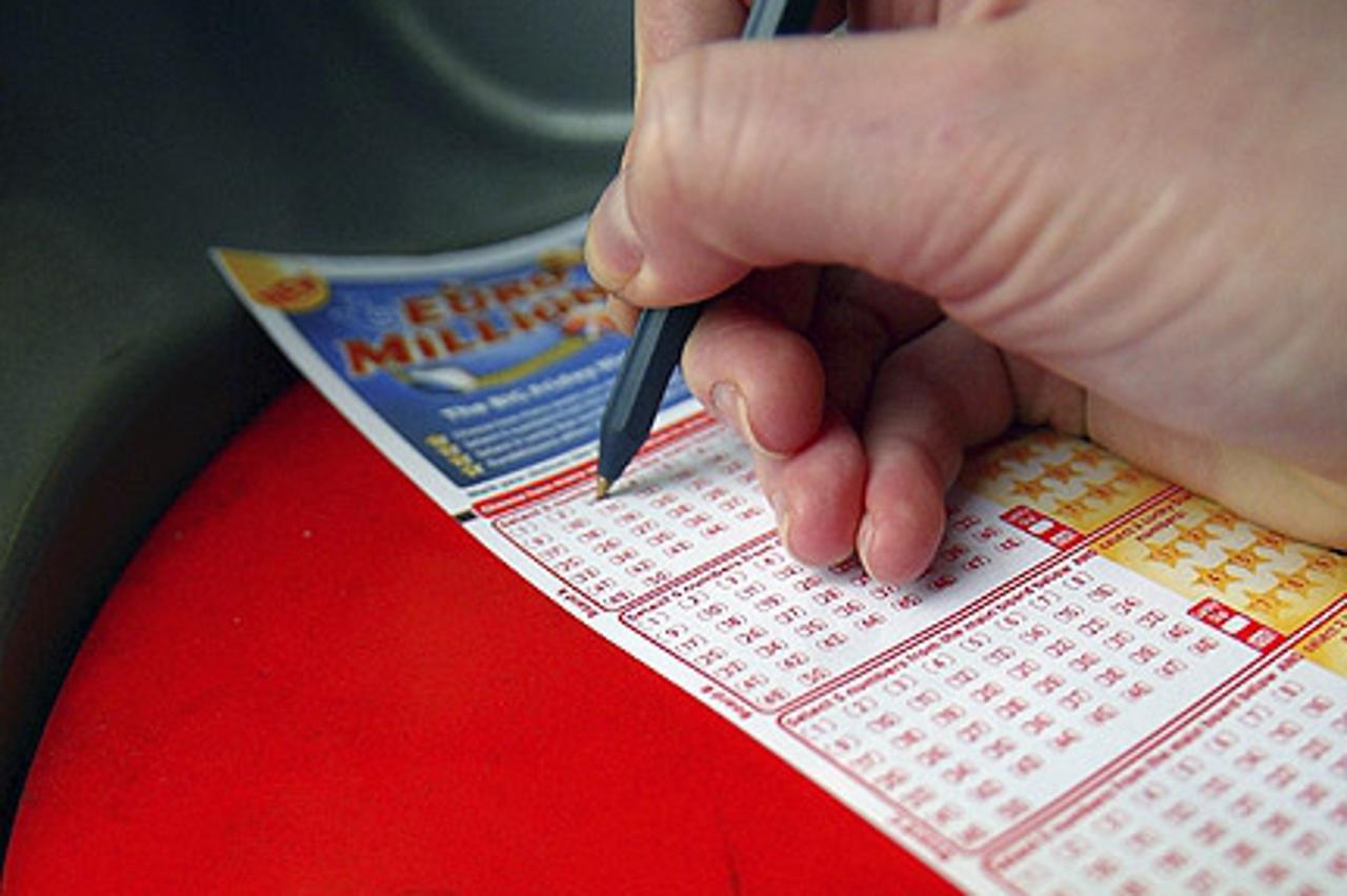 \'LONDON - FEBRUARY 12:  A woman fills out her ticket for the Euromillions first draw, February 12, 2004 in central London, England. The first draw of the new Euromillions lottery game will take place