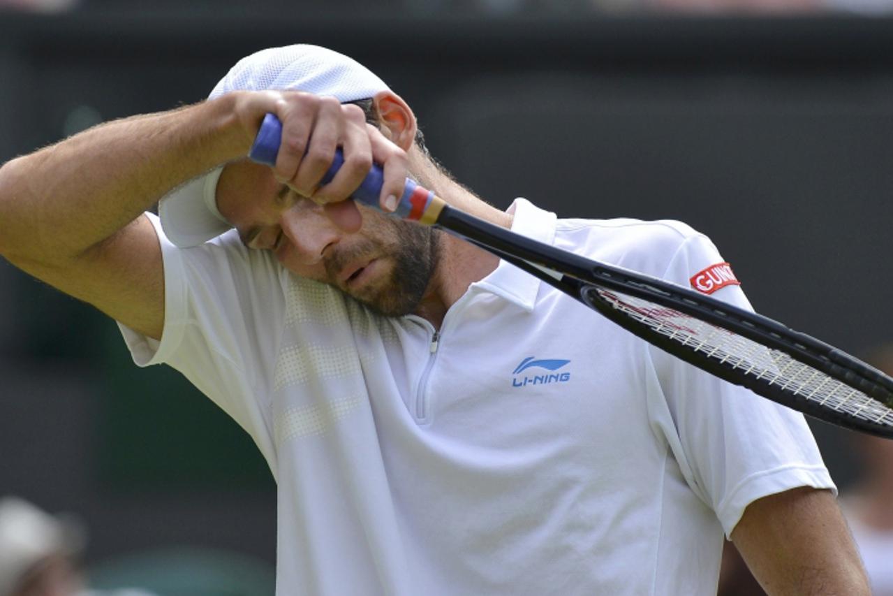 'Ivo Karlovic of Croatia wipes his face during his men's singles tennis match against Andy Murray of Britain at the Wimbledon tennis championships in London June 28, 2012.       REUTERS/Toby Melville