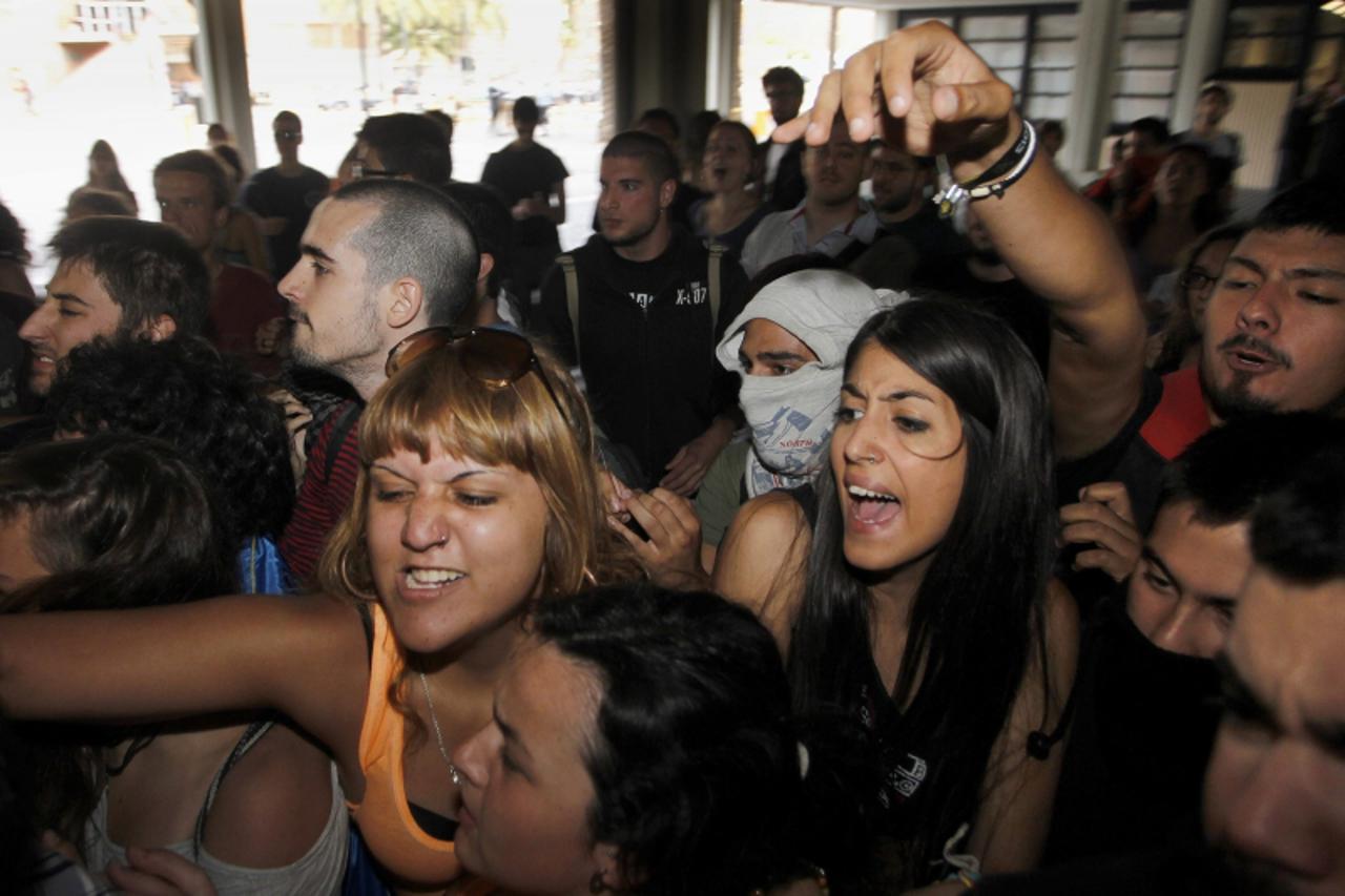 'Students, who are protesting against cuts in education, try to storm into the central hall at the Polytechnic University during the investiture ceremony of new rector Francisco Mora in Valencia June 