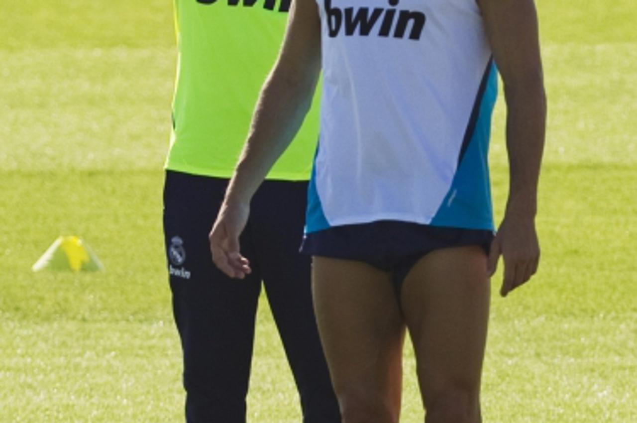 'Real Madrid coach Jose Mourinho (L) listens to Cristiano Ronaldo during a training session at Real Madrid's training grounds in Valdebebas, outside Madrid, August 16, 2012.    REUTERS/Susana Vera (S