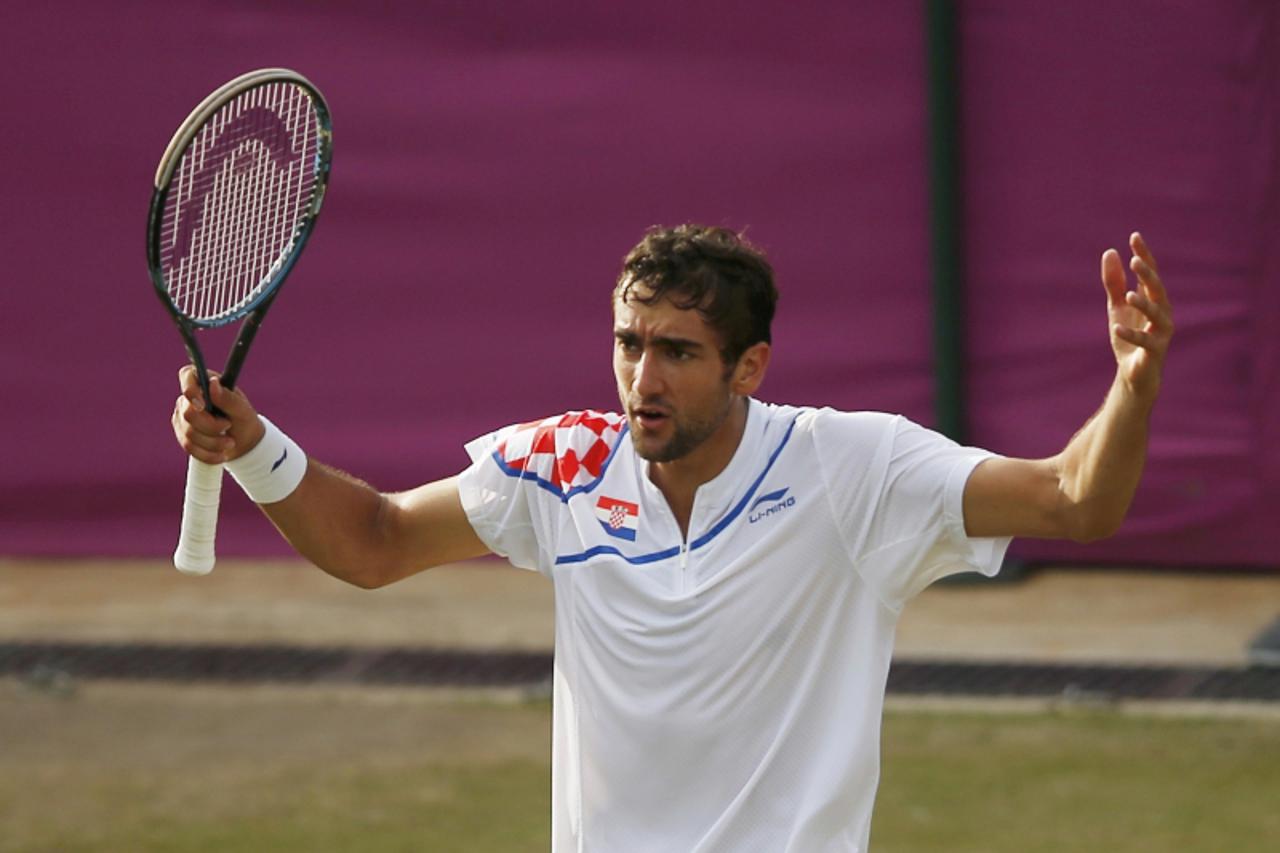 'Croatia\'s Marin Cilic argues with the referee over a call during his men\'s singles tennis match against Australia\'s Lleyton Hewitt at the All England Lawn Tennis Club during the London 2012 Olympi
