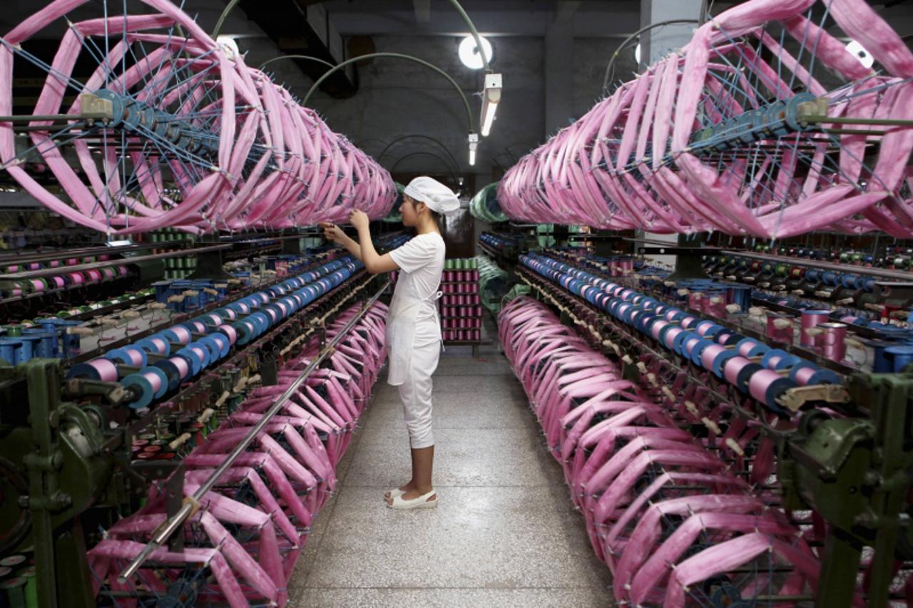 'An employee works inside a silk factory in Neijiang, Sichuan province, July 3, 2013. China's economy is expected to grow 7.6 percent in the second half of 2013. Picture taken July 3, 2013. REUTERS/C