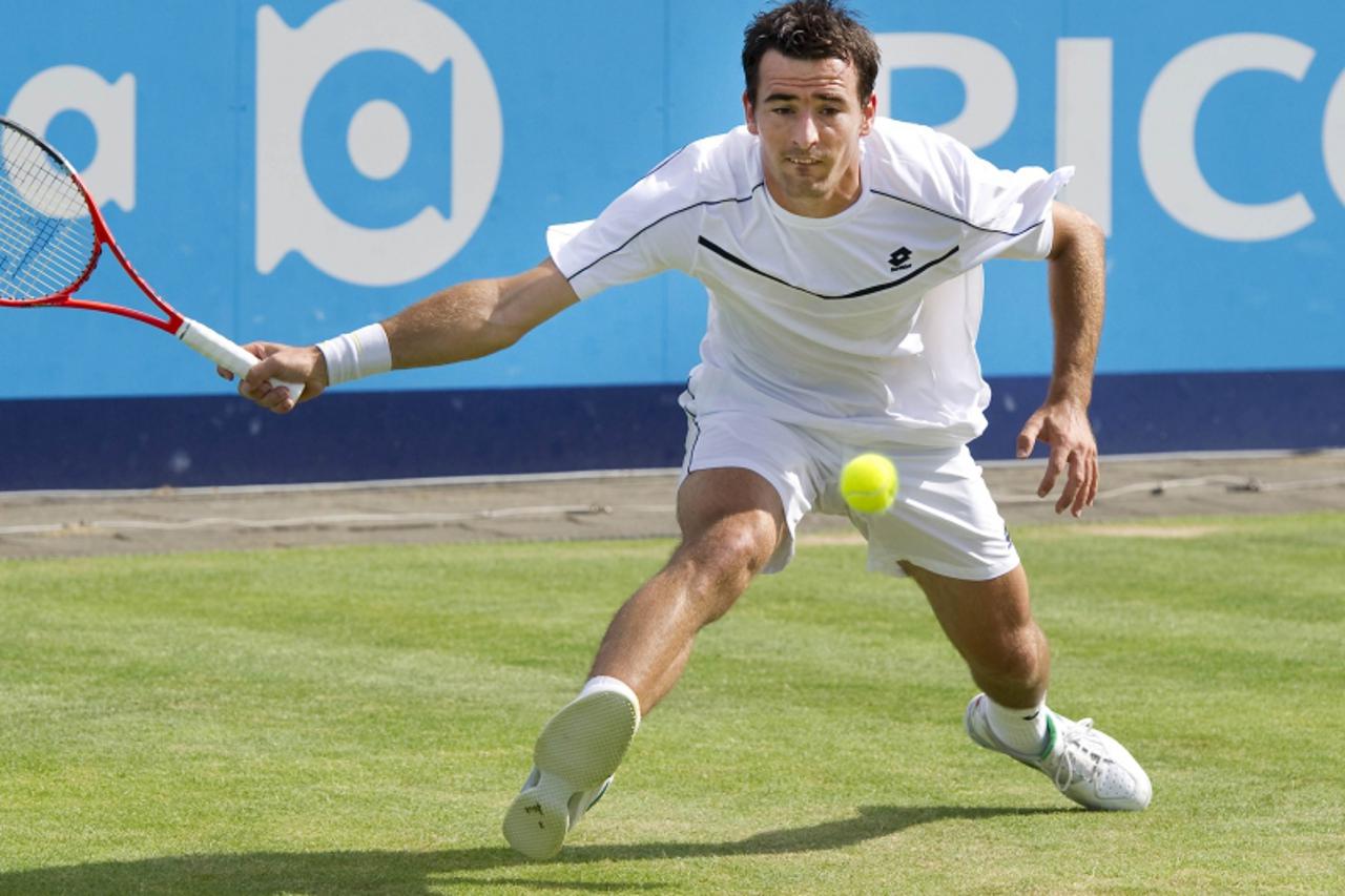 'Ivan Dodig of Croatia returns a shot to Dmitry Tursunov of Russia during their men\'s final match at the UNICEF Open tennis tournament in Den Bosch June 18, 2011. REUTERS/Paul Vreeker/United Photos (