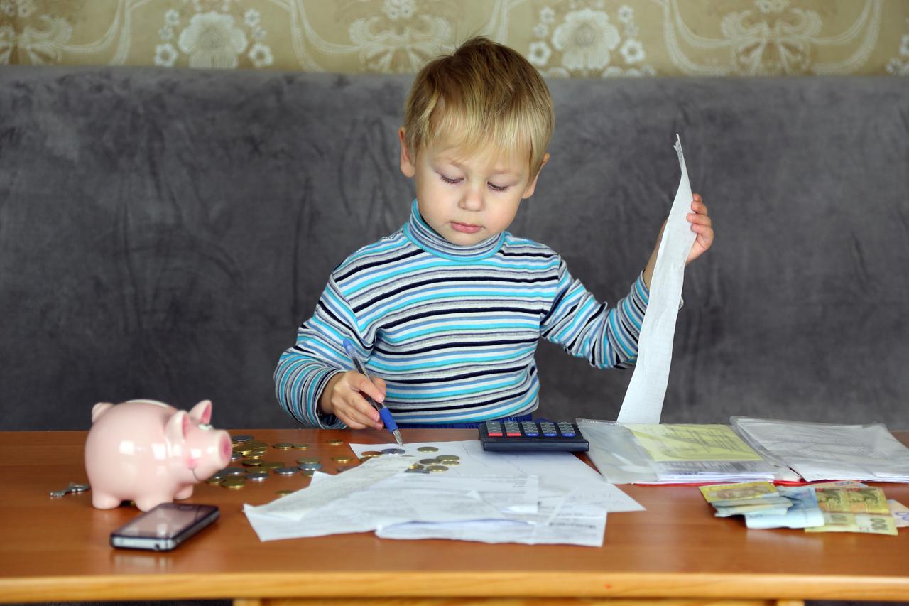 little boy is engaged in home accounting and finance