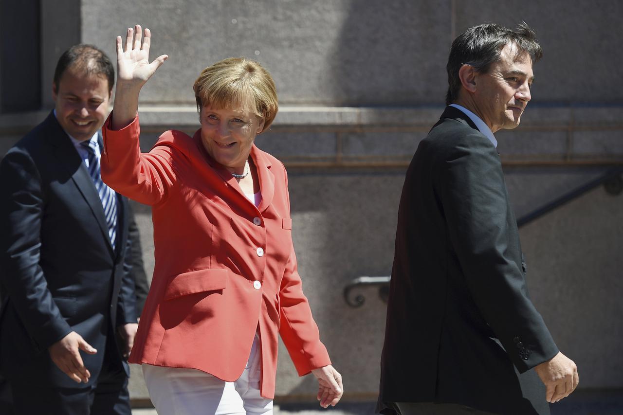 Germany's Chancellor Angela Merkel (C) waves to well-wishers as she arrives to tour the Australian and New Zealand Army Corps (ANZAC) Memorial in Sydney's Hyde Park November 17, 2014. REUTERS/Paul Miller/Pool (AUSTRALIA - Tags: POLITICS)