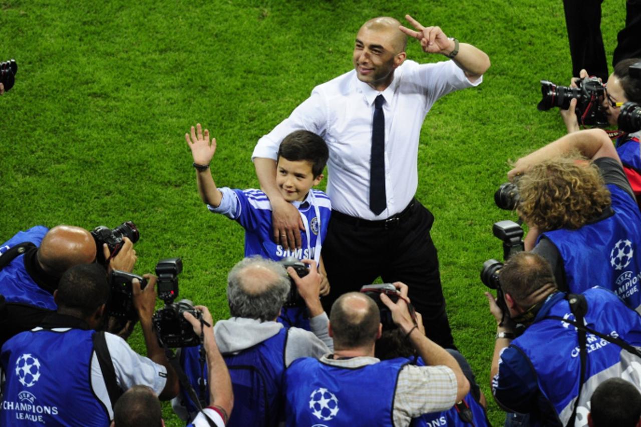 'Chelsea\'s Italian interim manager Roberto Di Matteo (C) makes the victory sign after winning the UEFA Champions League final football match between FC Bayern Muenchen and Chelsea FC on May 19, 2012 