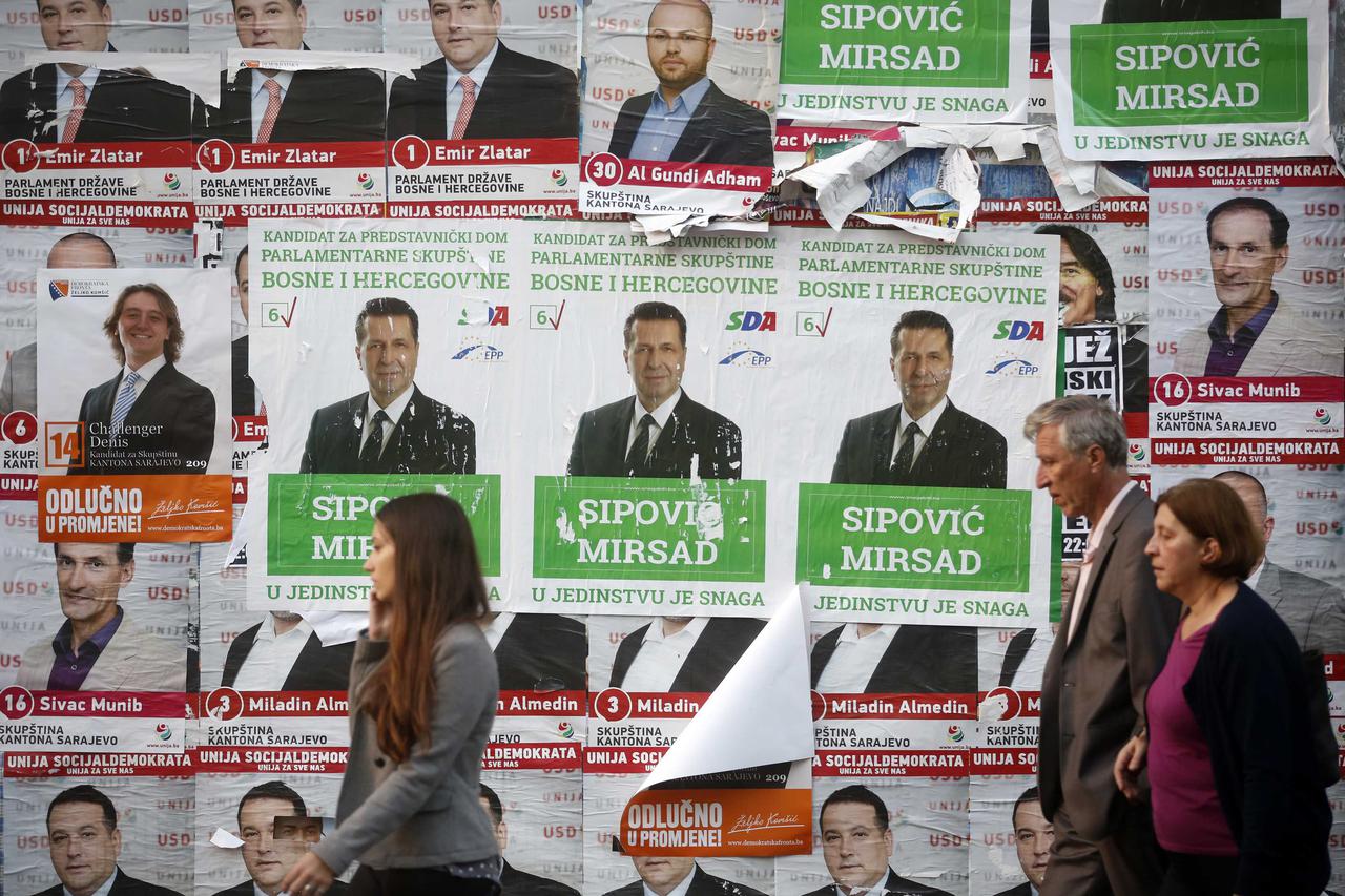 People walk past election posters in Sarajevo, October 10, 2014. Bosnians will vote on Sunday for a parliamentary and presidential election that could break the reform deadlock in the ethnically divided country or deepen divisions of the point of making i