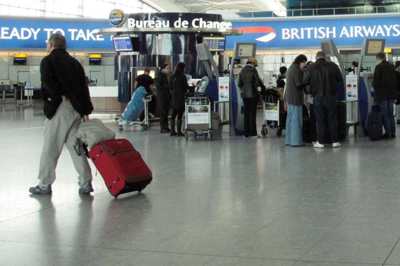 \'A passenger passes e-ticket check-in desks on the third day of a three day strike by British Airways cabin crew, at the departures floor of Terminal 5 at Heathrow Airport in west London March 22, 20