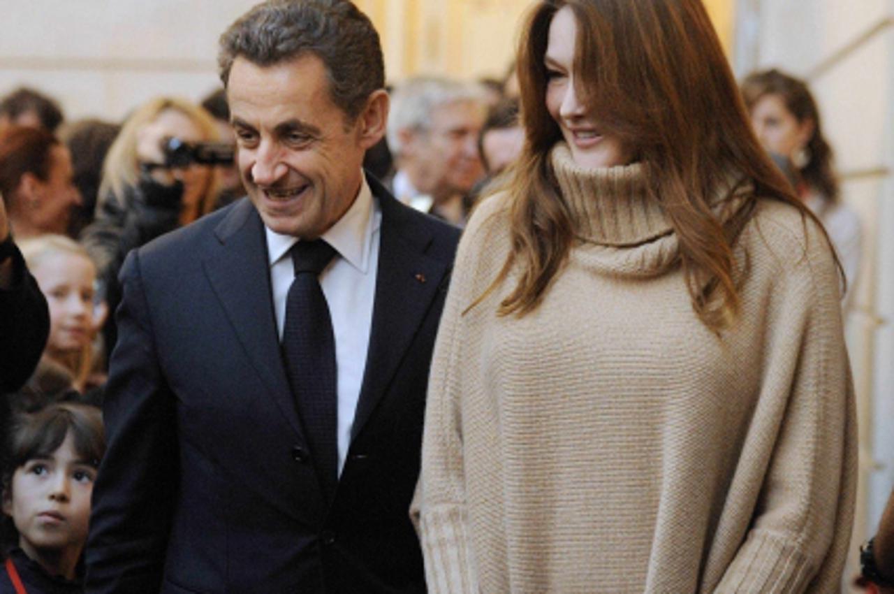 \'France\'s President Nicolas Sarkozy (L) and his wife Carla Bruni-Sarkozy attend a Christmas party at the Elysee Palace in Paris December 14, 2011.   REUTERS/Eric Feferberg/Pool (FRANCE - Tags: POLIT