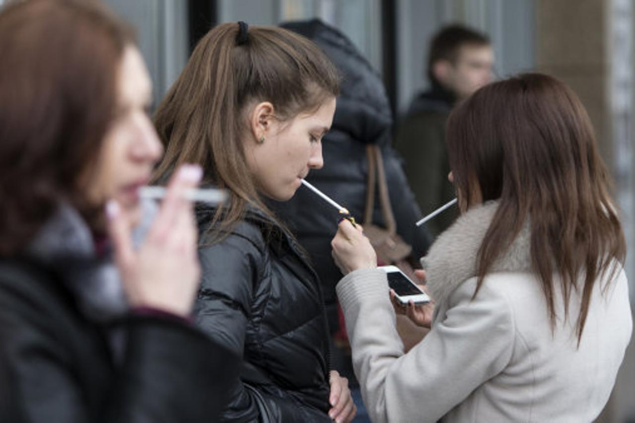 Women smoke cigarettes at a shopping center in Moscow, Russia, Tuesday, Feb. 12, 2013. Russia's lower house of parliament has overwhelmingly passed a bill that would ban smoking in public places, a contentious measure in a country with one of the highest 