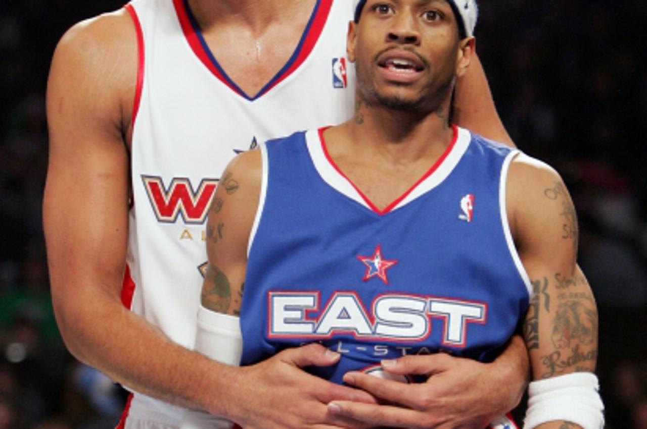 'Tim Duncan of the San Antonio Spurs (L) holds Philadelphia 76\'ers guard Allen Iverson during a timeout in the second half of the 54th NBA All-Star Game in Denver, February 20, 2005.   REUTERS/Lucy N