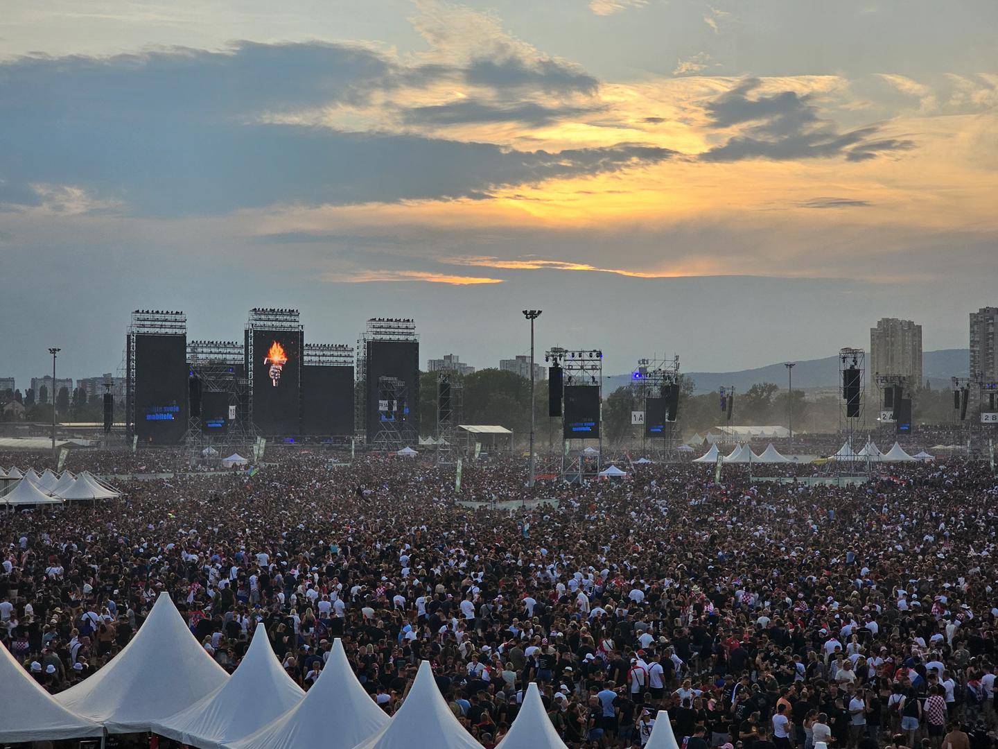 Nešto nakon 21 sat, kad padne mrak, trebao bi početi koncert Marka Perkovića Thompsona, a na Hipodrom su ušle stotine tisuća ljudi. Iako je na Hipodromu gomila ljudi, još ima prostora, a kako sve to izgleda pogledajte na fotografijama. 