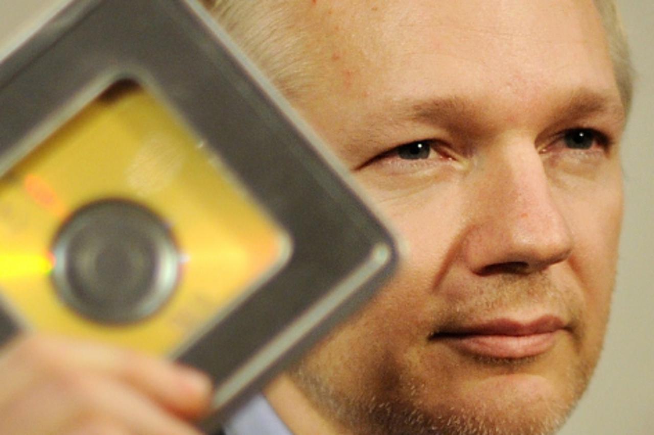 \'WikiLeaks founder Julian Assange holds a CD during a press conference at the Frontline club in London, on January 17, 2011. An offshore banking whistleblower on Monday personally handed WikiLeaks fo