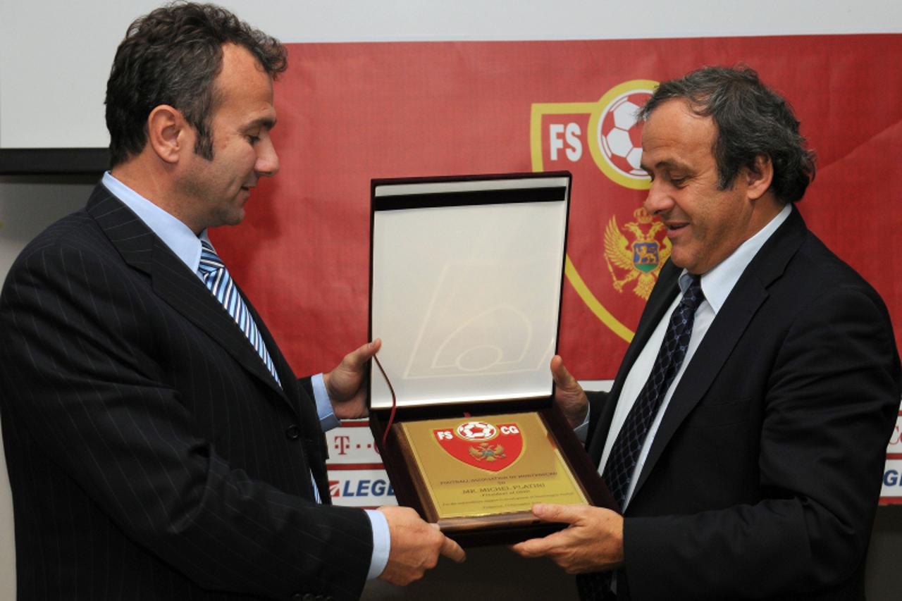 \'UEFA President Michel Platini (R) receives a plaque  from the president of Montenegro\'s Football Association, Dejan Savicevic, in Podgorica on November 13, 2010.   AFP PHOTO / Savo PRELEVIC\'