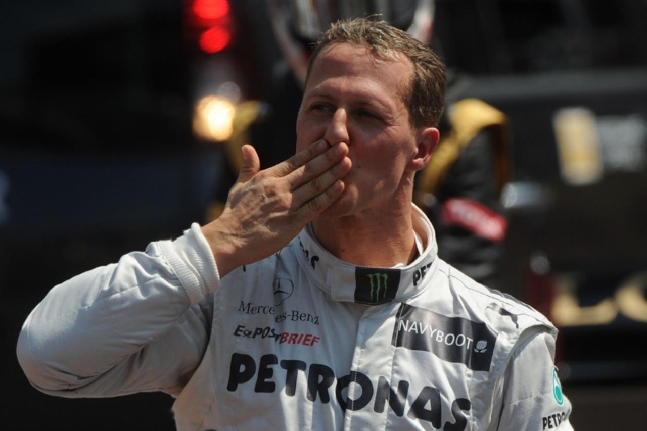 'German driver Michael Schumacher blows a kiss in the parc ferme after the qualifying session at the Circuit de Monaco on May 26, 2012 in Monte Carlo ahead of the Monaco Formula One Grand Prix.    AFP