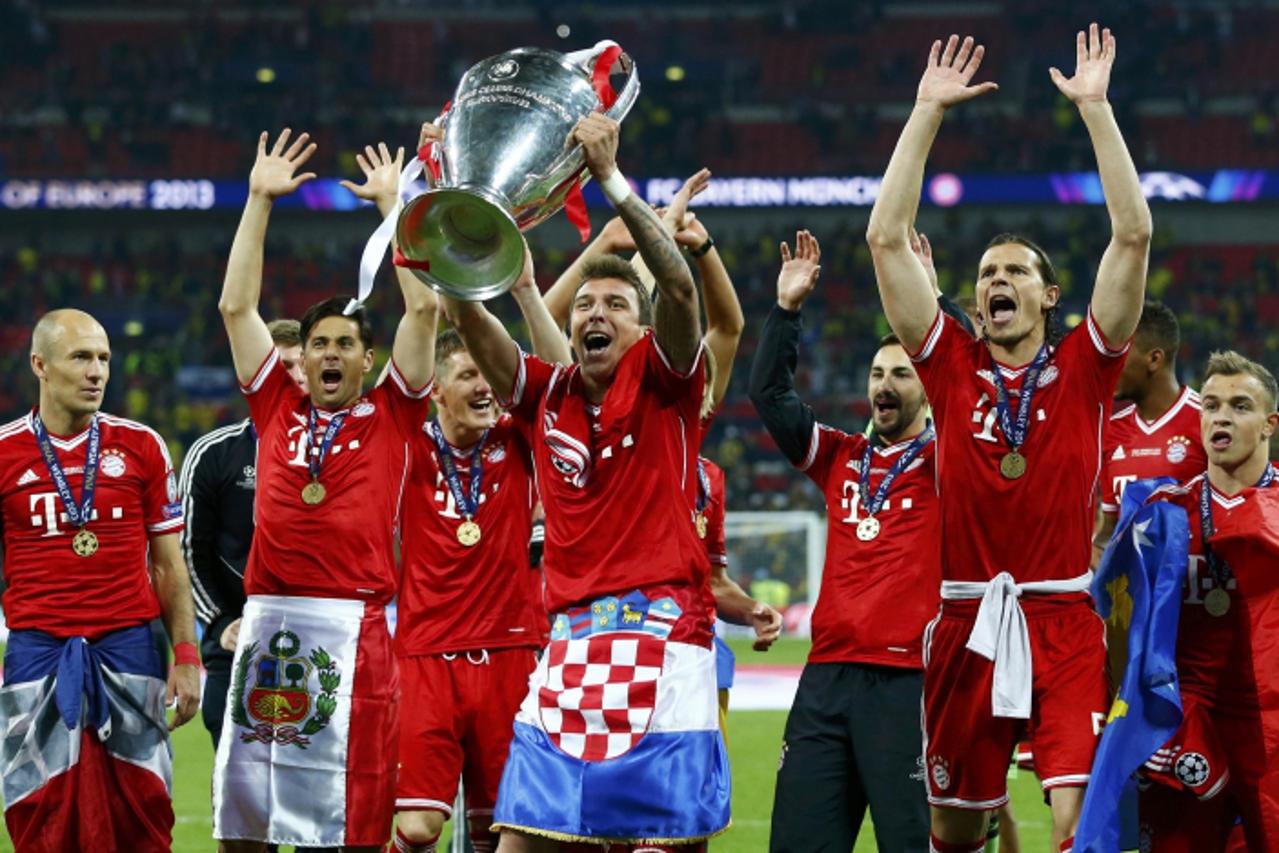 'Bayern Munich's Mario Mandzukic (C) holds up the Champions League Trophy after defeating Borussia Dortmund in their Champions League Final soccer match at Wembley Stadium in London May 25, 2013.    