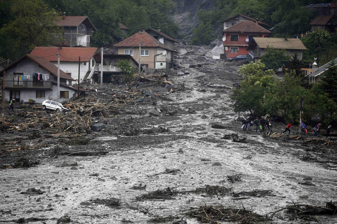People carry their belongings as they evacuate from their flooded houses in Topcic Polje, near Zepce May 16, 2014. The heaviest rains and floods in 120 years have hit Bosnia and Serbia, killing five people, forcing hundreds out of their homes and cutting 