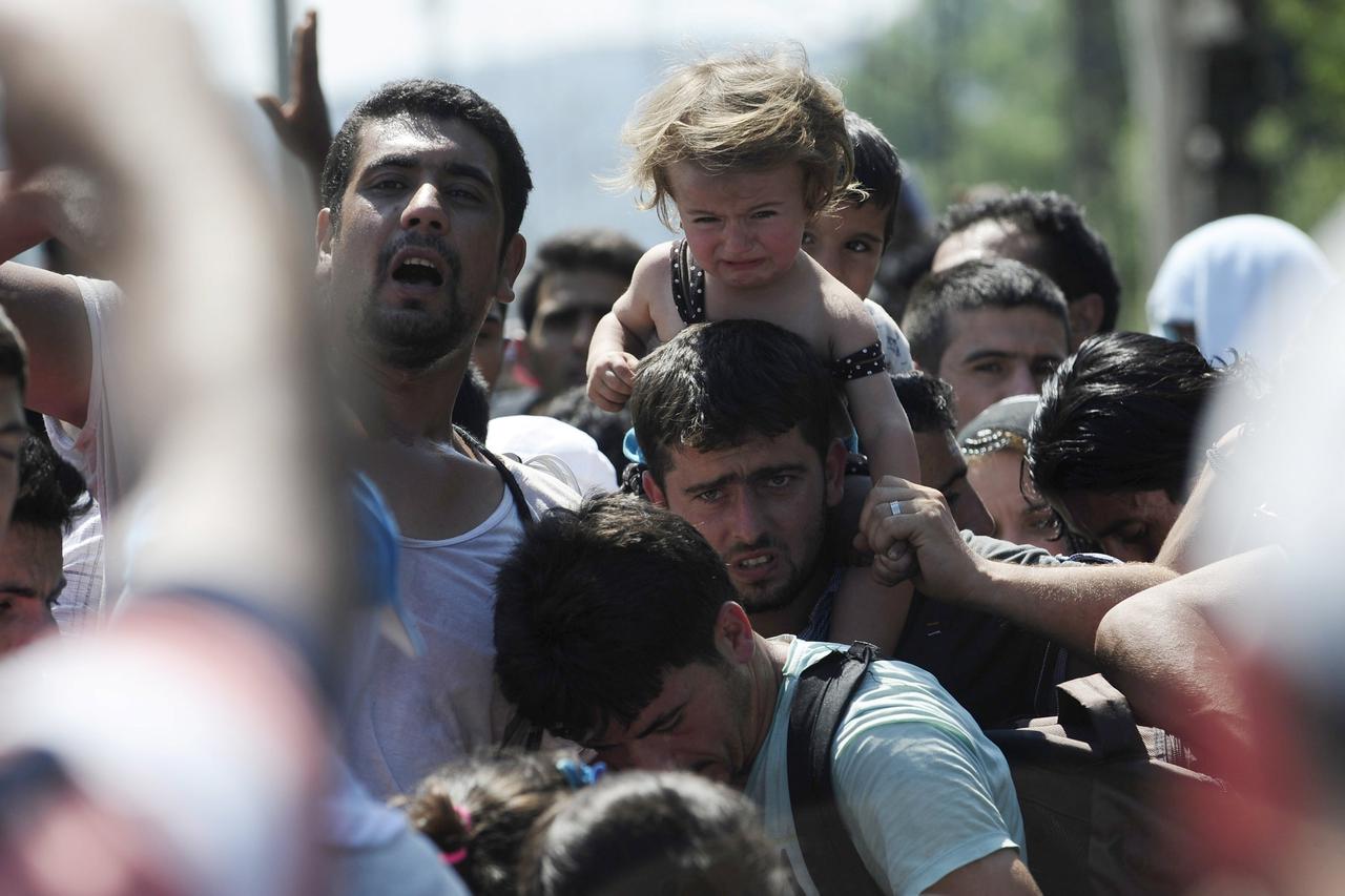 Migrants standing at the Greek side of the border wait to cross into Macedonia, near Gevgelija August 24, 2015. State authorities and aid agencies threw up tents and scrambled to supply food and water to thousands surging through the western Balkans, thei